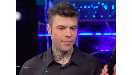 Fedez con l'aria confusa sul palco, Conti lo accompagna nel backstage